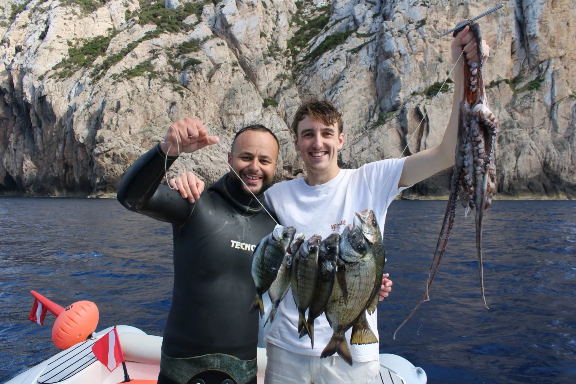 Pesca subacquea ad Alghero con pescato davanti alle falesie